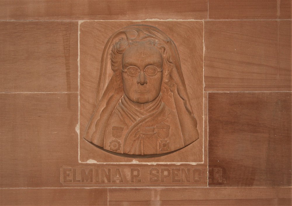 A depiction of Elmina Spencer is shown carved into reddish brown stone at the New York State Capitol in Albany.