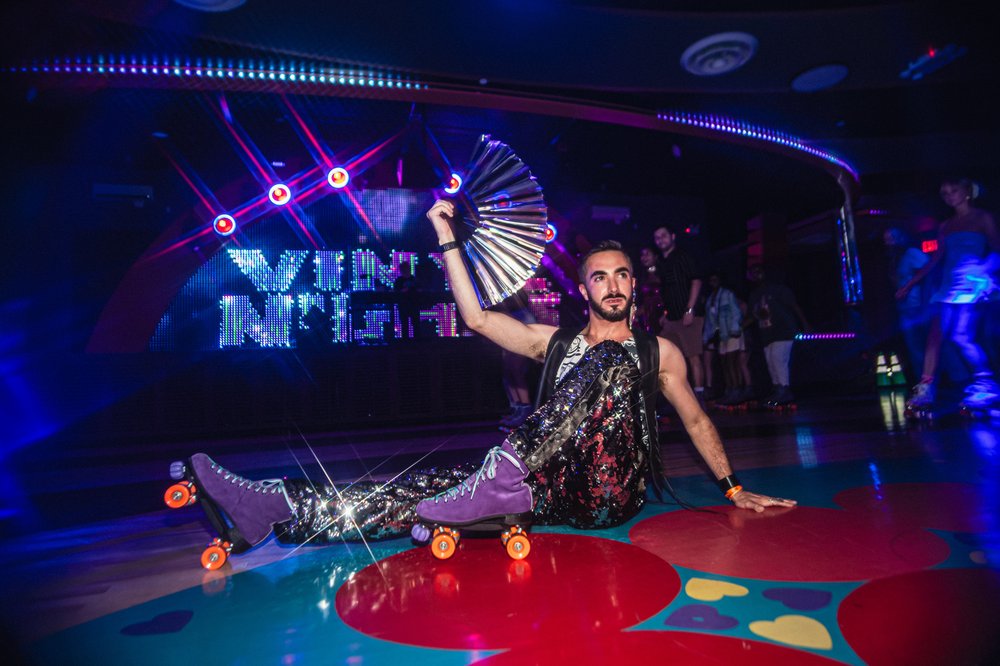 A person on rollerskates poses while lounging on the floor.