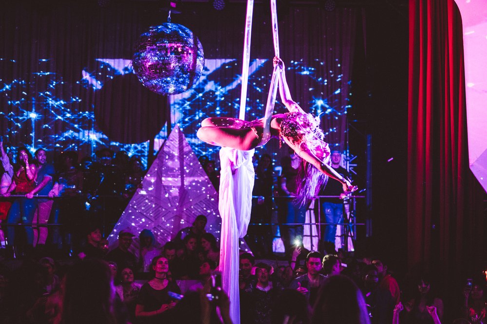 A person onstage performs aerial moves