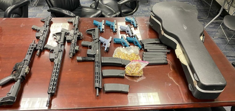 Some of the guns and ammunition and the guitar case that were seized as part of a law enforcement investigation into an alleged gun trafficking ring in Queens
