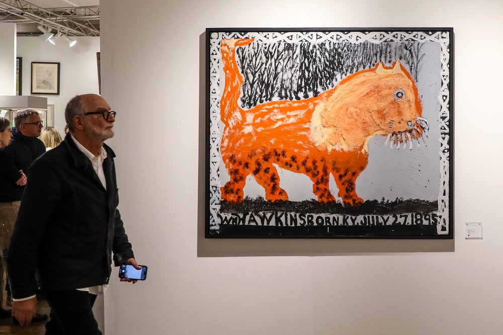 outsider-8.jpg A large picture of an orange cat hangs on a wall