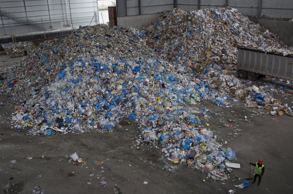 A large pile of plastic recycling in a garage