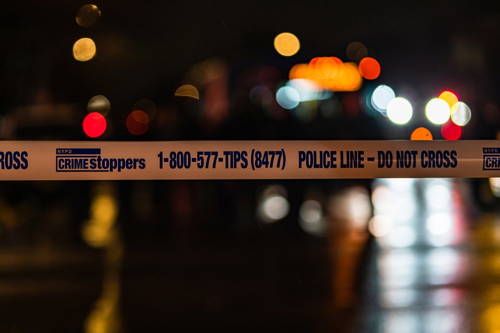 Police tape in the foreground of a street scene