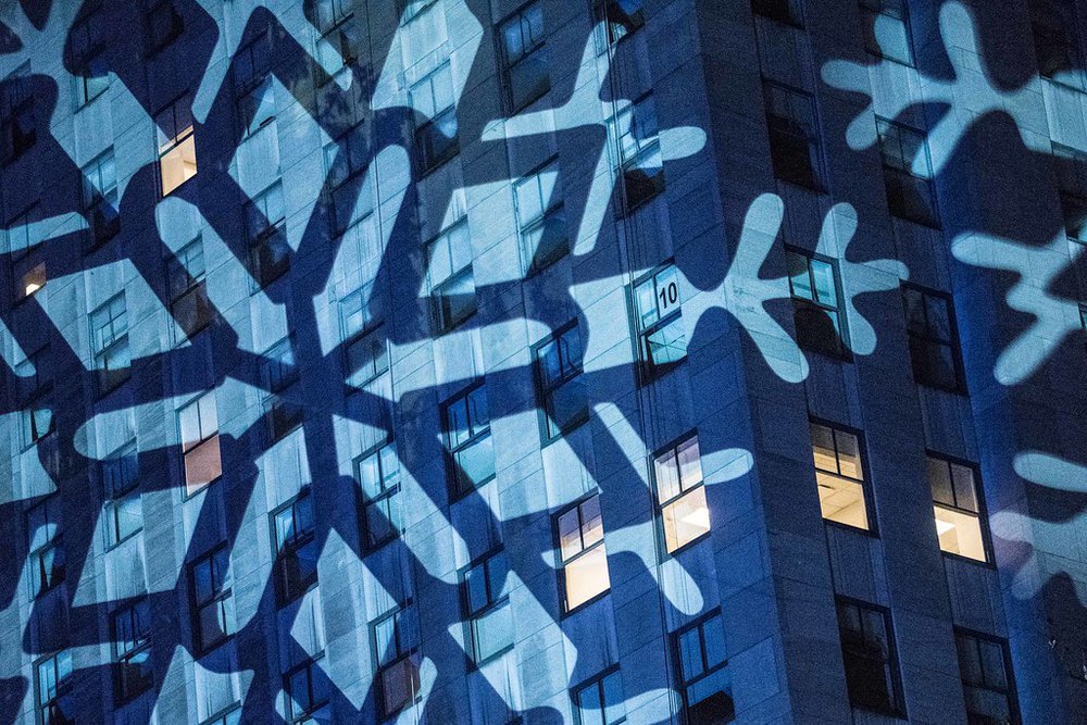 A snowflake is projected onto a building at Rock Center