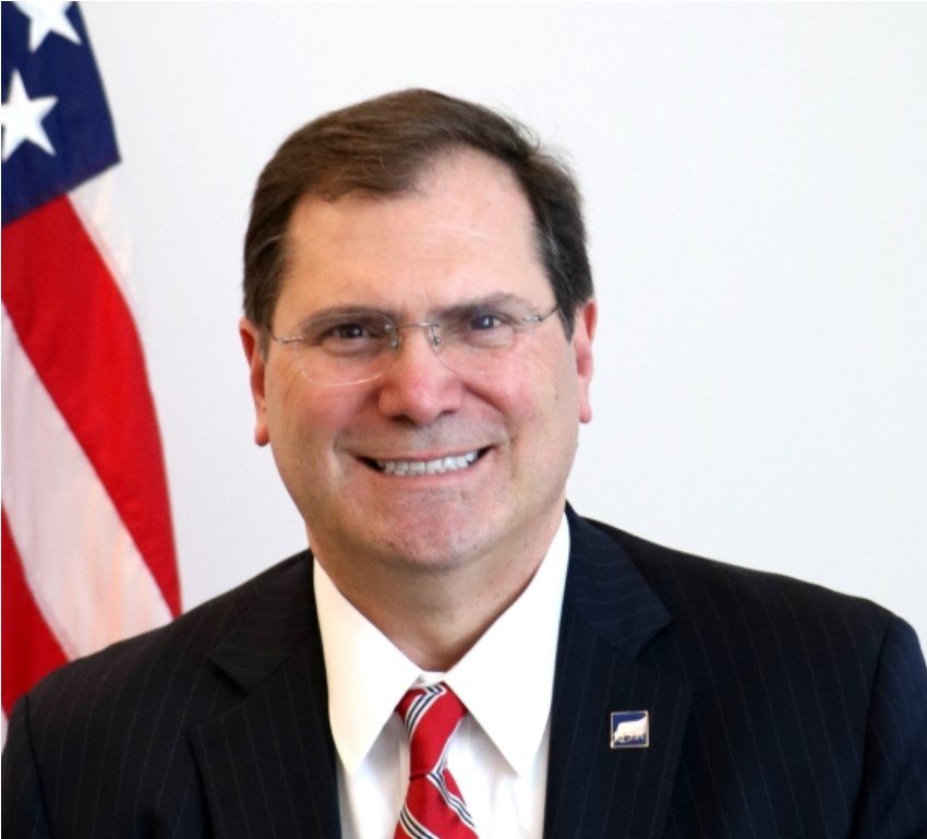 A headshot of a man in a suit.