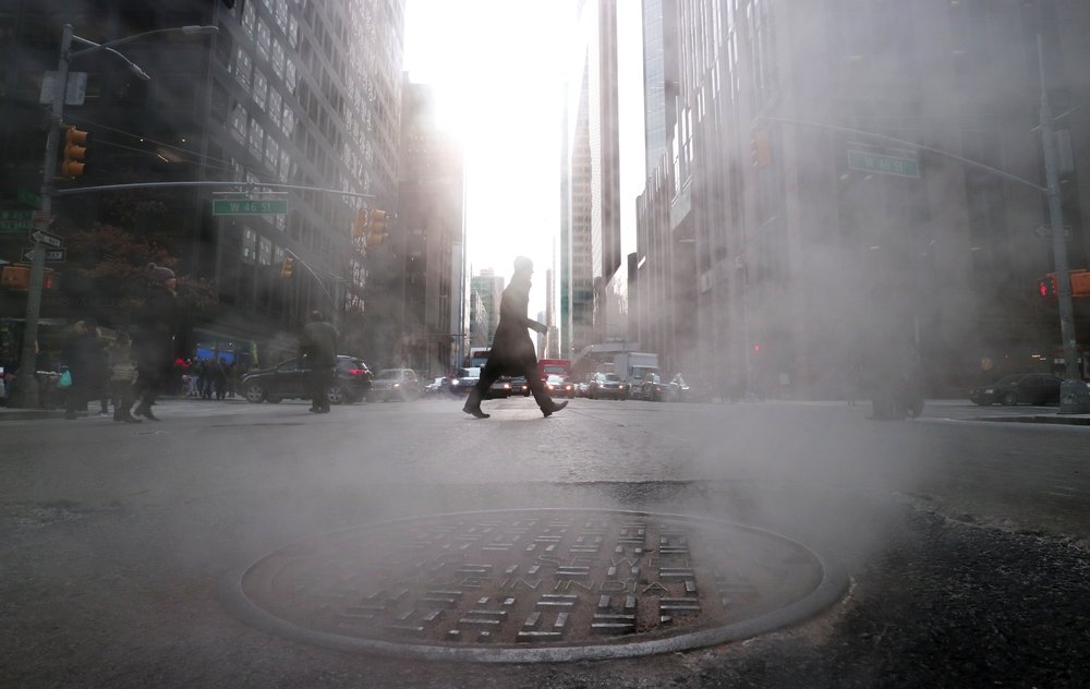 Steam rises from a sewer as a man crosses Sixth Avenue on February 1, 2019 in New York City.