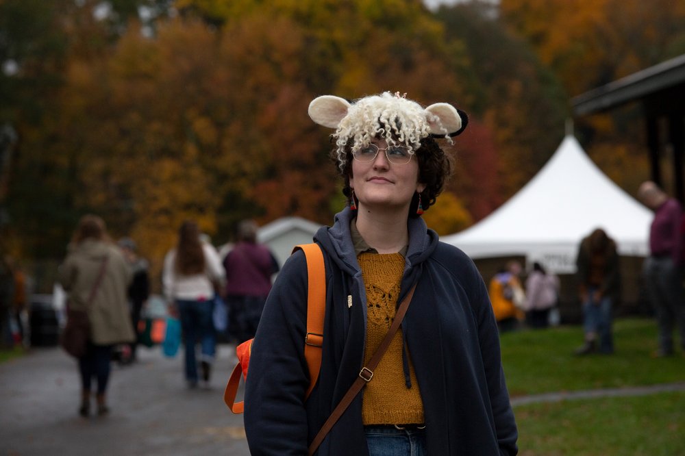 A person wears a wool hat designed to look like a sheep.