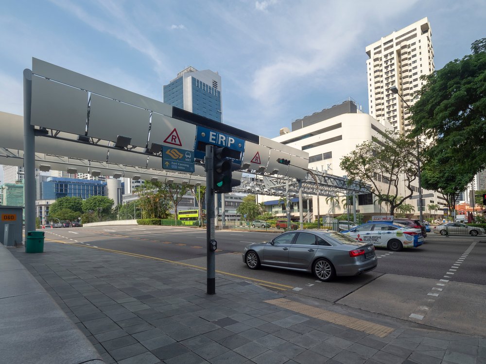 An "electronic road pricing" sign with cameras above a street.