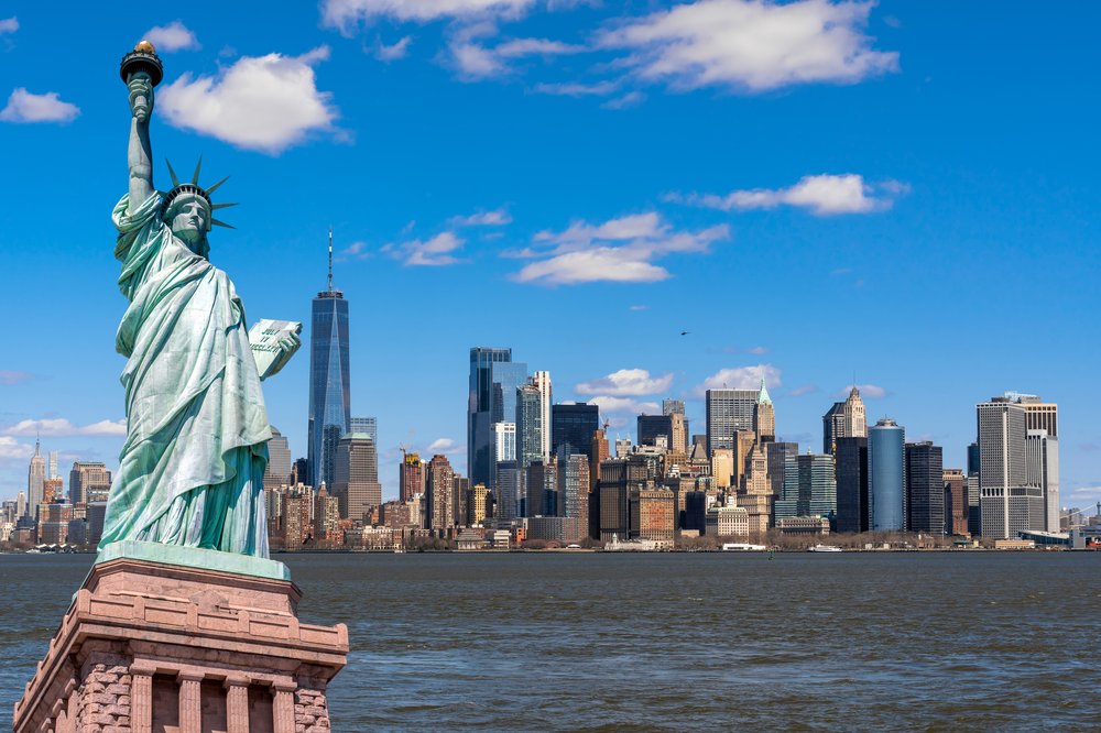 the statue of liberty in front of buildings