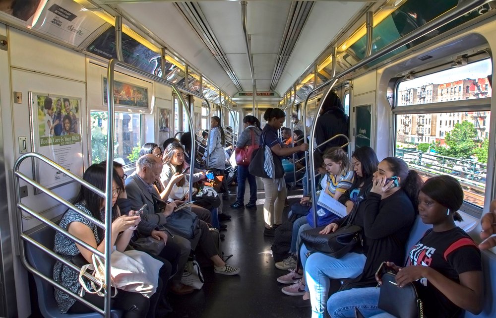 Straphangers seated in a MTA subway car.