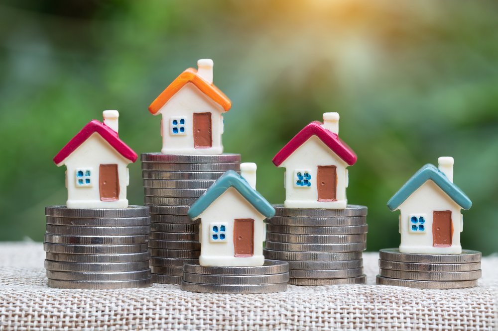 Figurines of houses stacked on coins