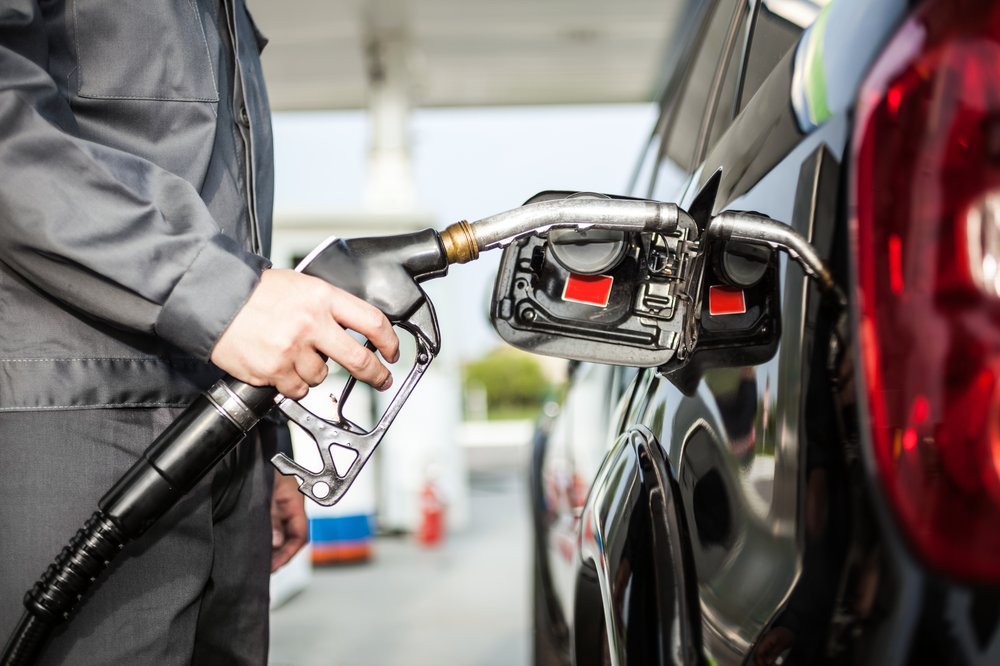 A gas station attendant pumps gas.