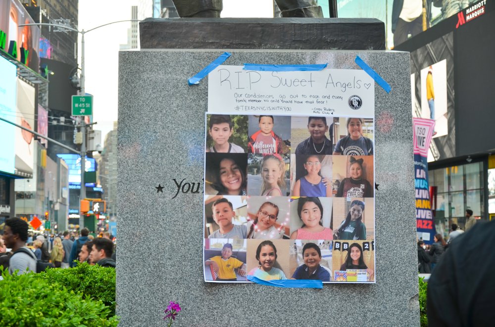 Photos of Deceased Texan school children is seen taped up on Father Duffy's statue in New York City