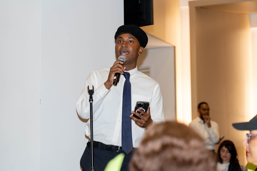 Councilmember Chi Osse, in a white button down shirt, tie and black beret, speaks at a Rent Guidelines Board meeting
