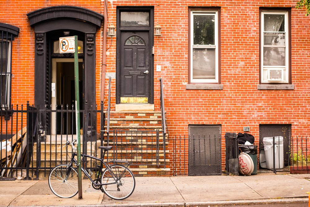 A bicycle is parked in front of an apartment building.