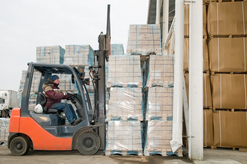 A forklift operator and a stack of pallets.