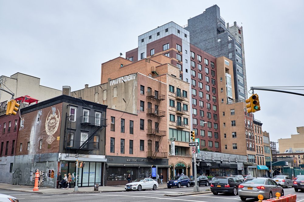 A view of traffic and apartment buildings on the Bowery.