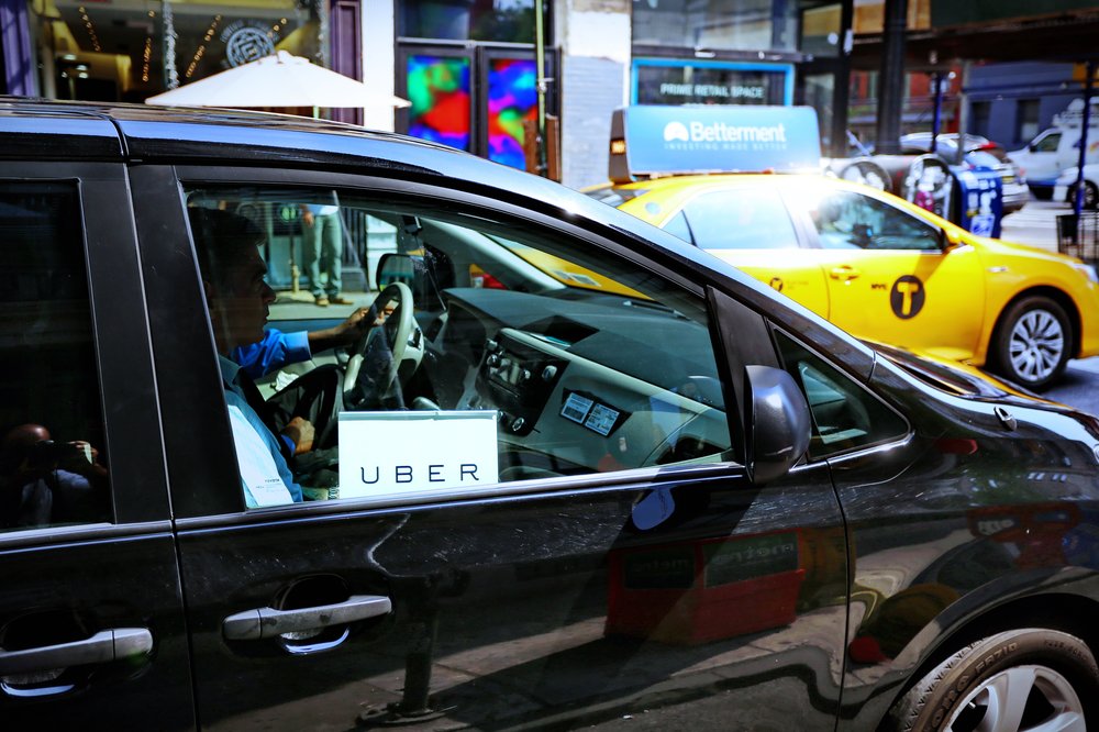 A black van with an Uber sign in the passenger window.