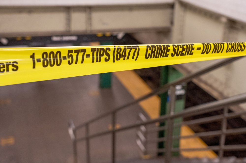 Police tape blocks the entrance to a New York City subway platform.