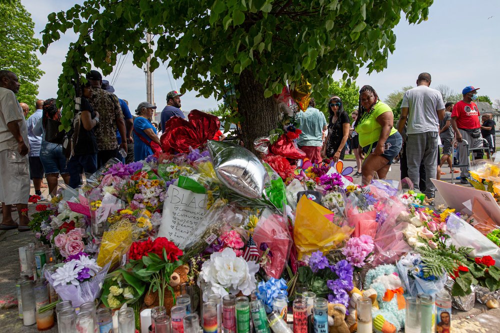 People walk by a memorial for the victims of the Buffalo supermarket shooting outside the Tops Friendly Market, in Buffalo.