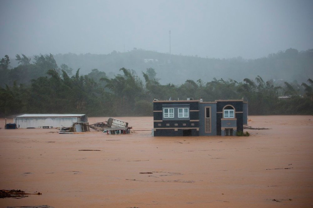 Three people inside a house await rescue from the floods caused by Hurricane Fiona in Cayey, Puerto Rico