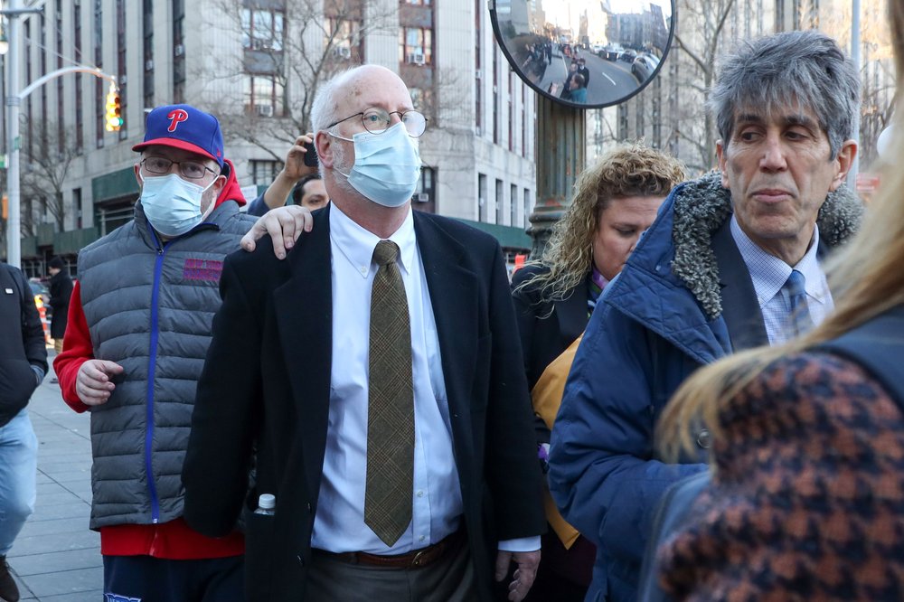 A man wears a face mask leaving a courthouse.