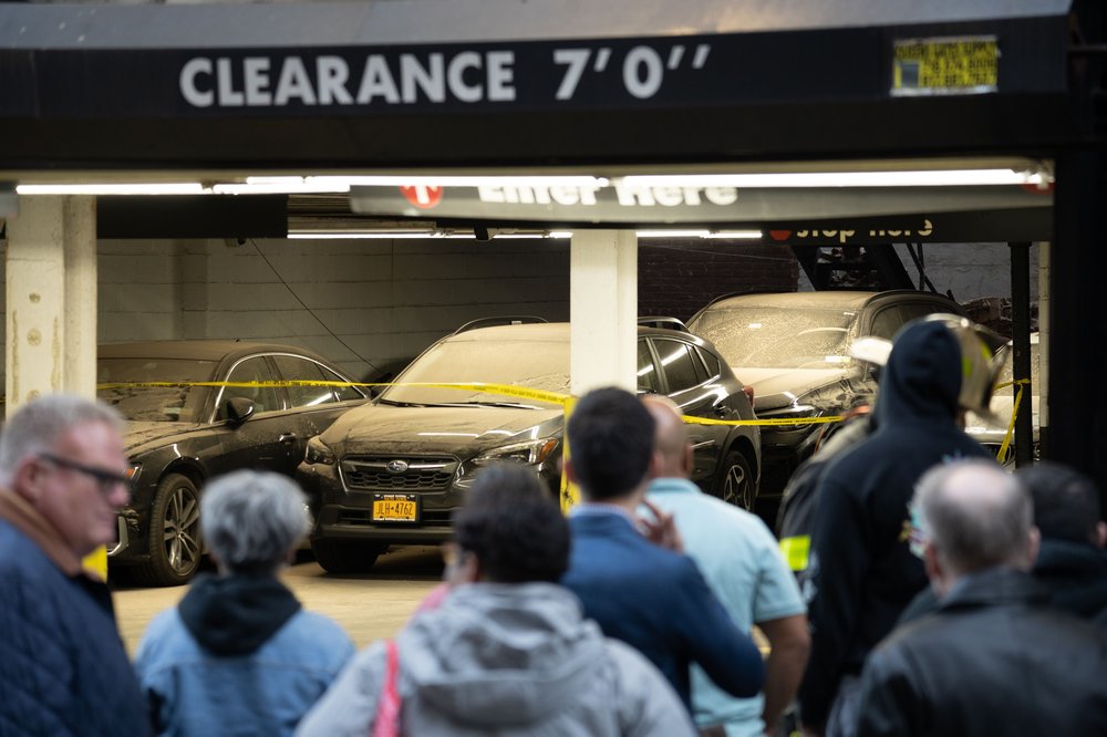 People wait to get their cars from the Rapid Park on the other side of the garage that collapsed in Lower Manhattan.