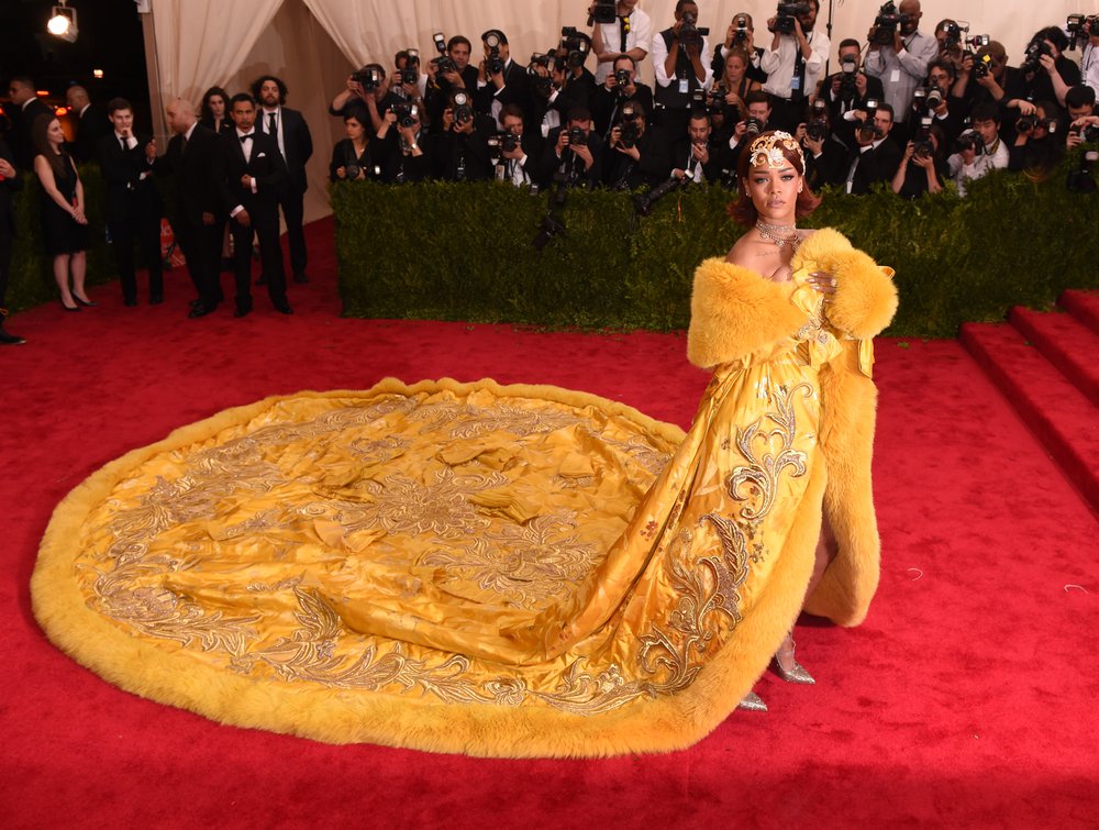 Rihanna in the yellow Guo Pei coat, with a huge train fanned out behind her. The coat also had yellow fur trim.