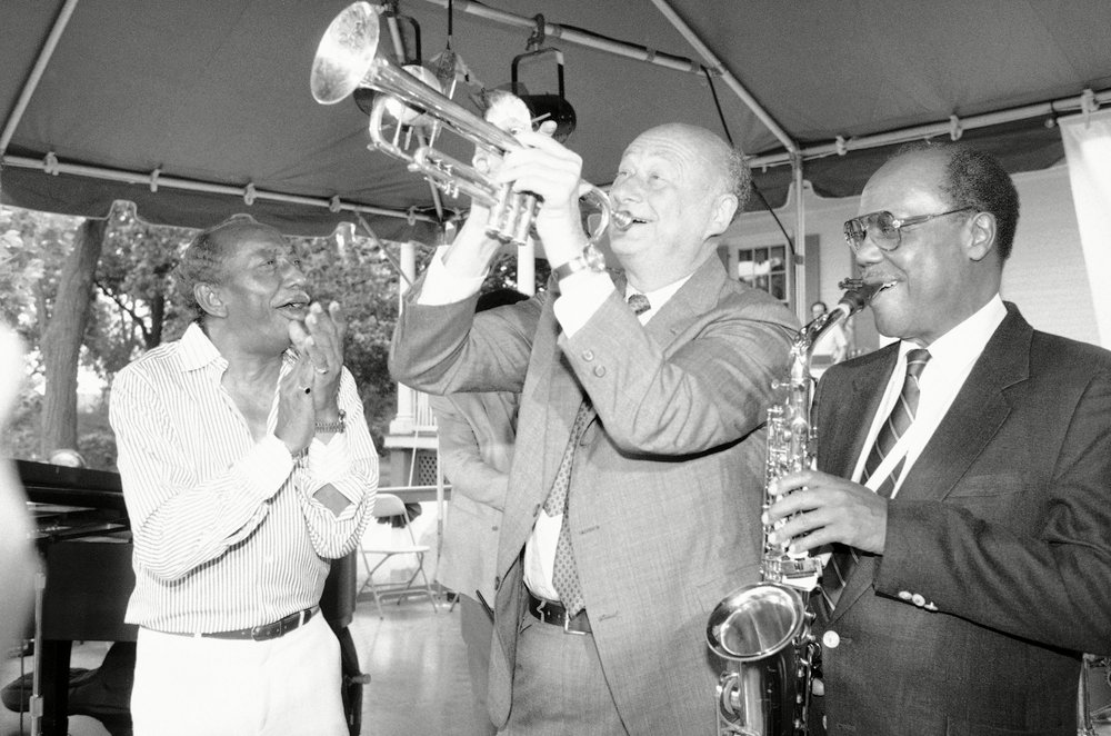 Mayor Ed Koch plays the trumpet alongside Joe Newman and Norris Turney. Koch hosted a picnic at Gracie Mansion to kick off the JVC Jazz Festival. 1986.