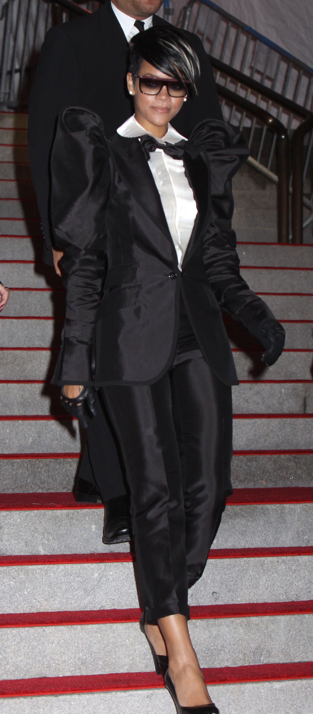 Rihanna in a black suit with puffed sleeves and cropped pants, with a white shirt, at the 2009 Met Gala