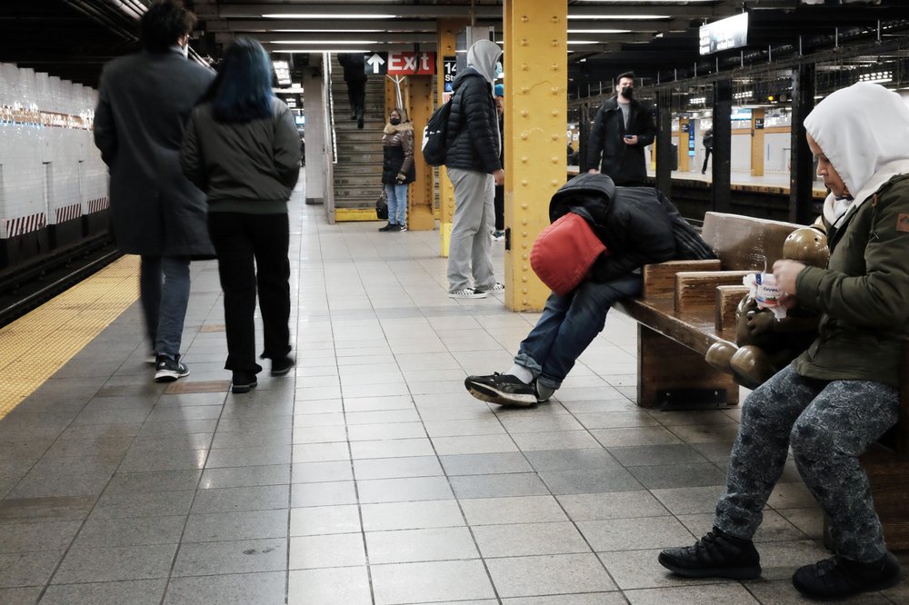 A man sleeps on a subway platform in Manhattan on January 19, 2022. Mayor Eric Adams has expanded rules to forcibly remove people who appear to not be meeting their basic needs and send them to hospitals.