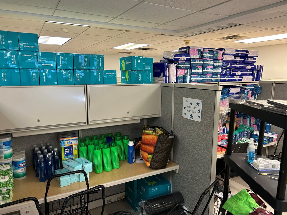 Cleaning supplies and other good piled on office desks.