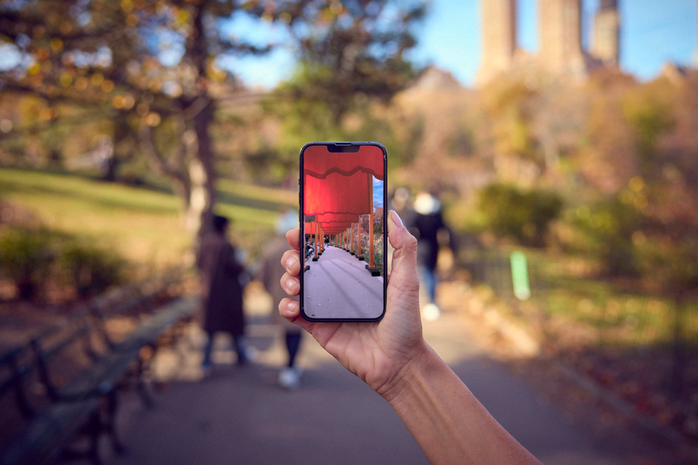 A person holds up a cell phone in Central Park