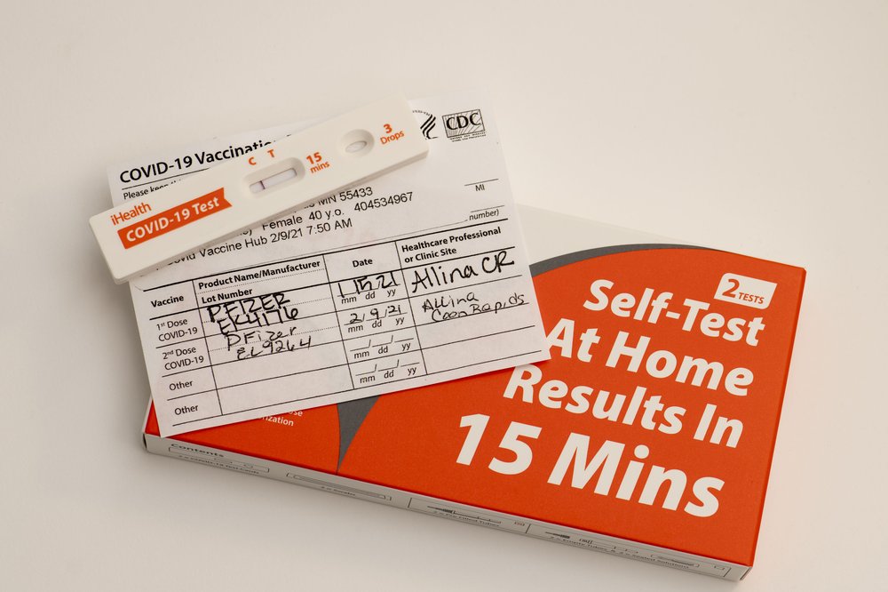 COVID-19 home test kit laying on vaccination card.