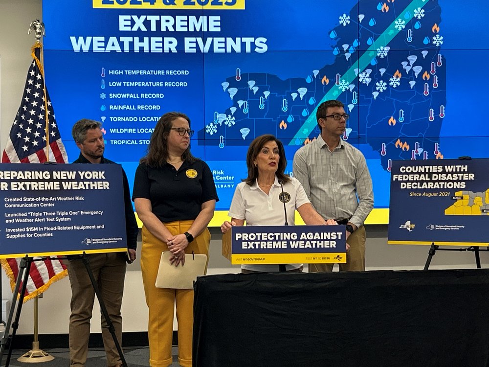 Gov. Hochul holds a press conference in front of a big map of New York.