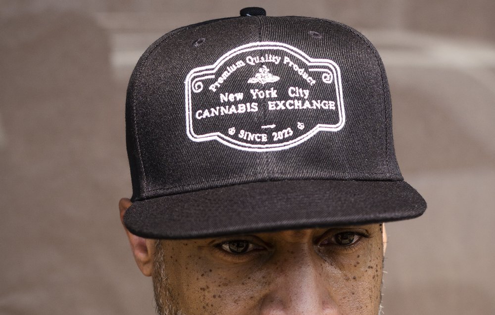 A person wearing a hat that reads "New York City Cannabis Exchange."