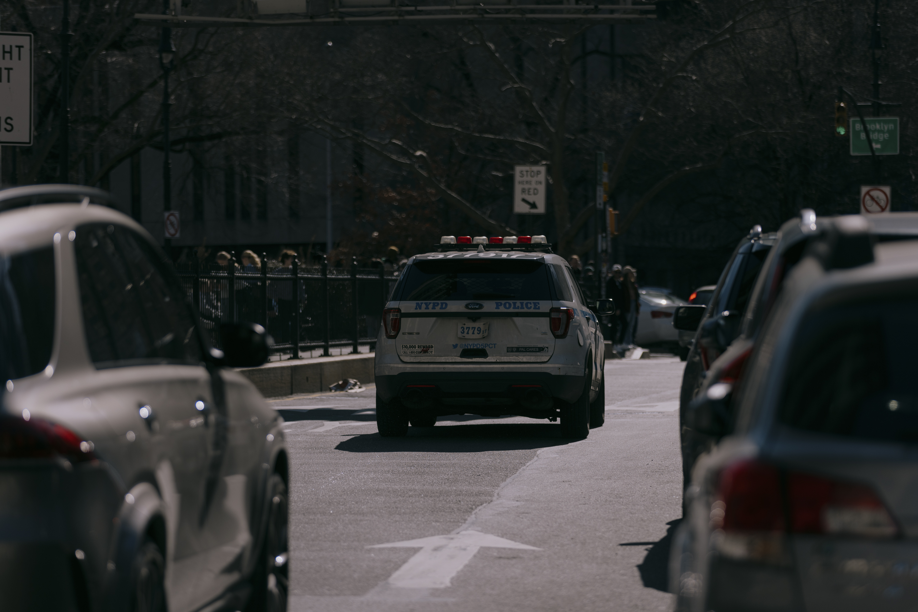 NYPD vehicles make their way south on Centre Street towards the Brooklyn Bridge.