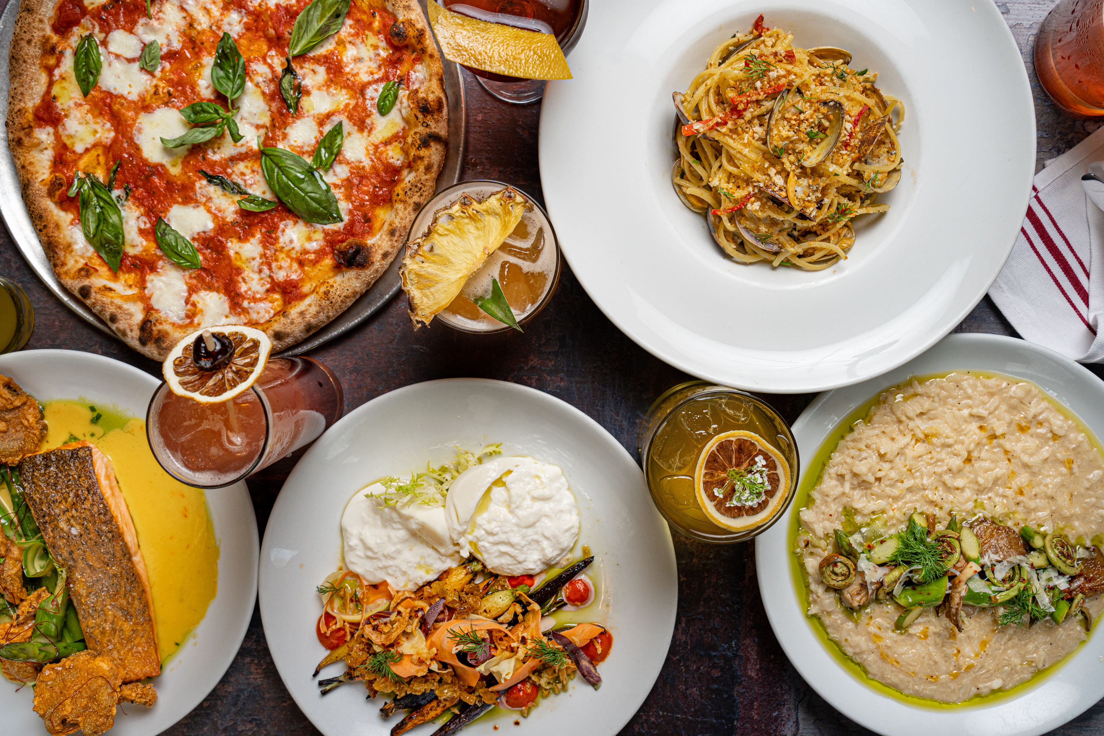 A tables with pasta, pizza and other dishes.