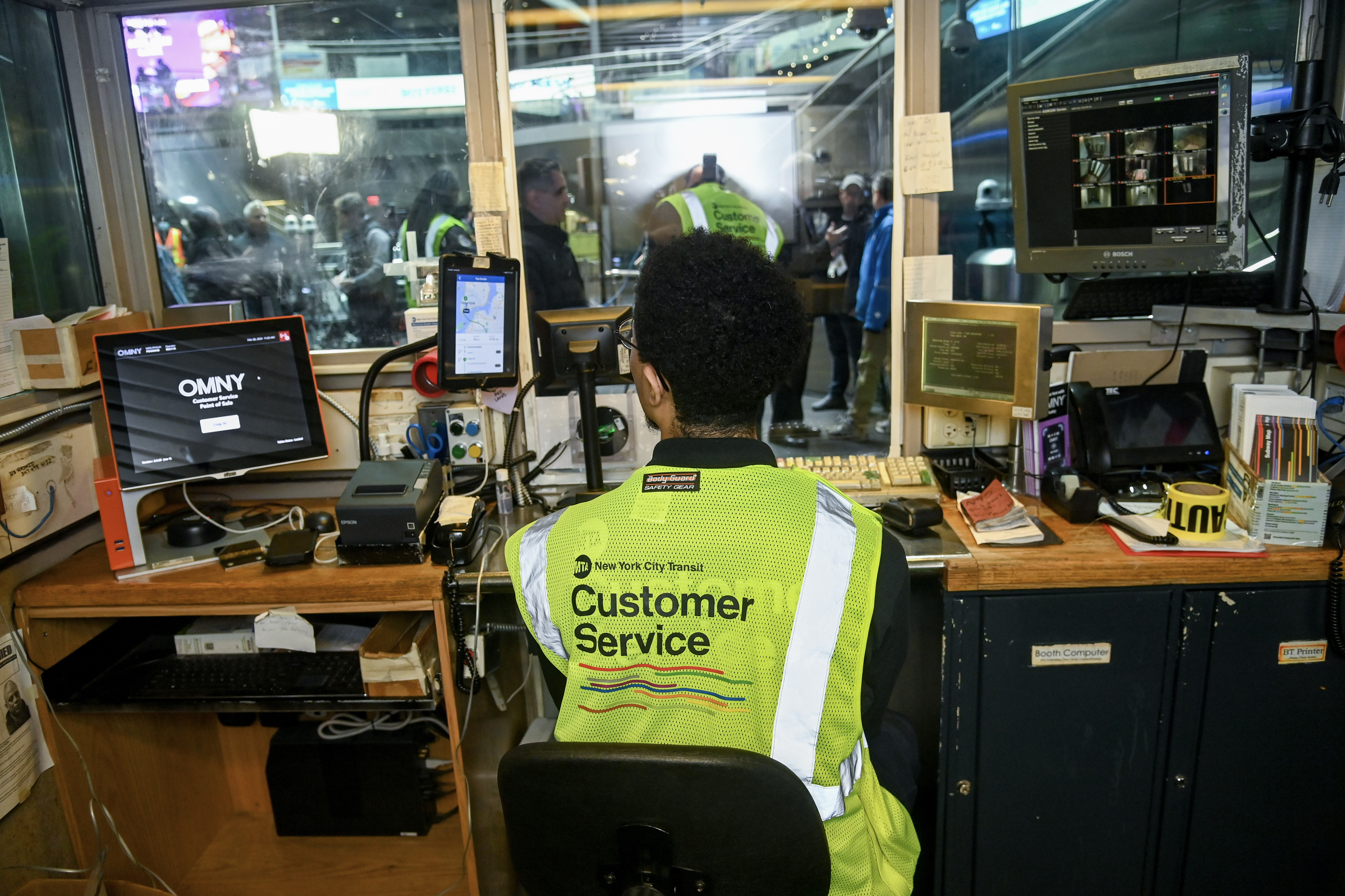 An MTA worker in a customer service booth.