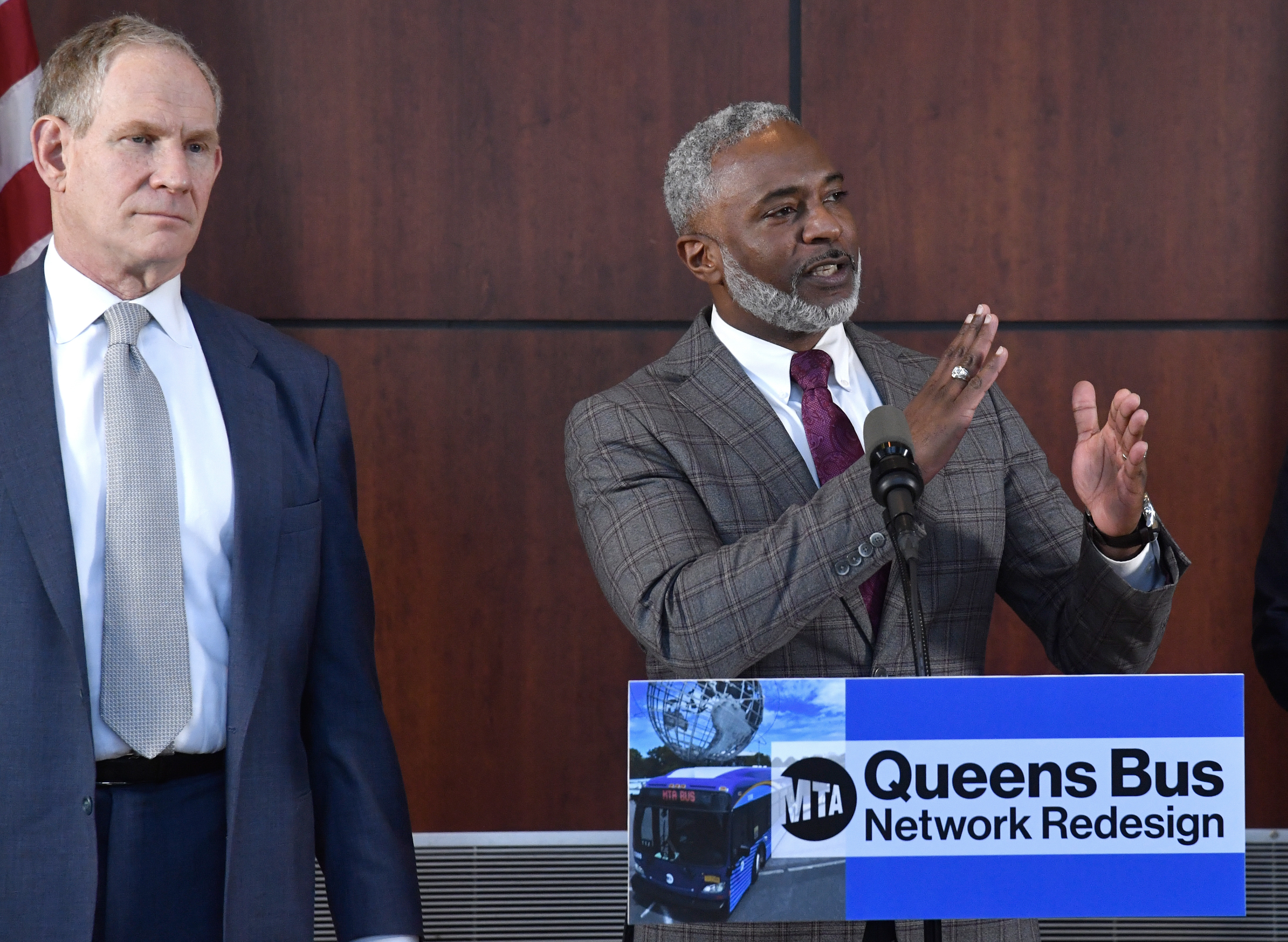 Two MTA officials in front of a podium.