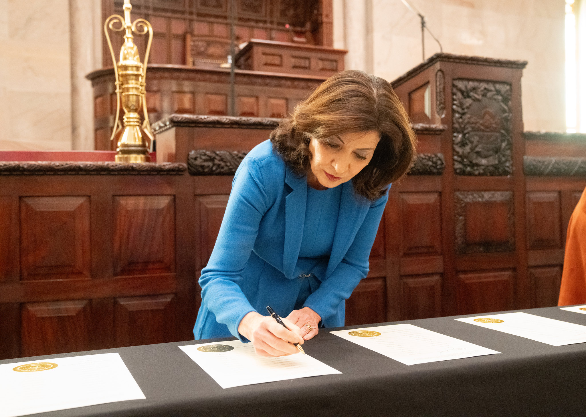 Governor Kathy Hochul signs a bill in Albany