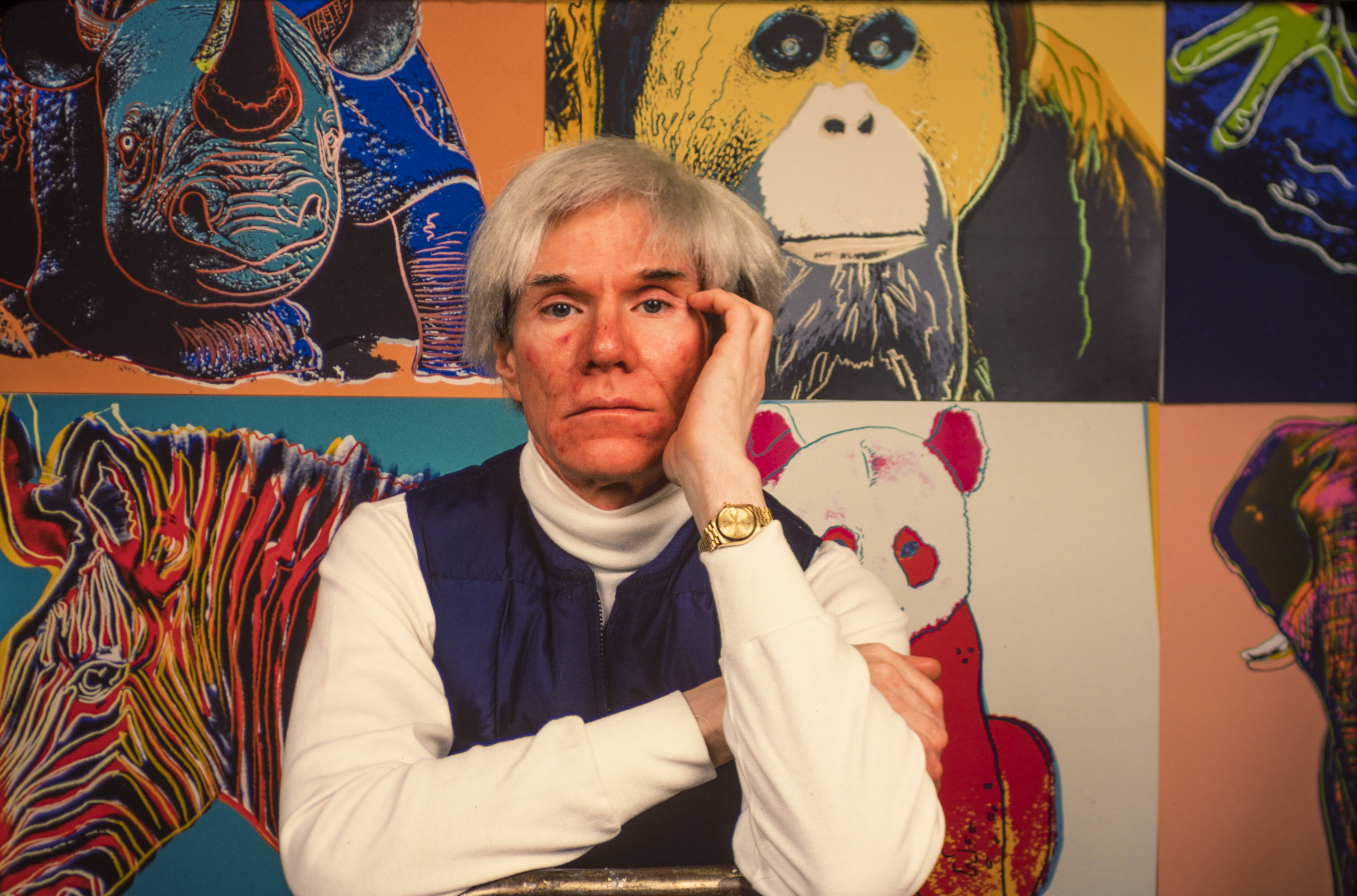 Famous artist Andy Warhol stands in front of his work.