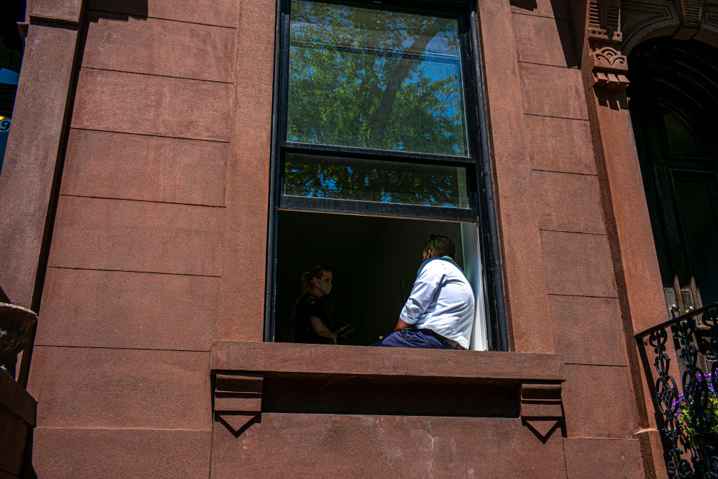 A real estate broker, right, shows an empty apartment to a potential client May 15, 2021 in New York City.