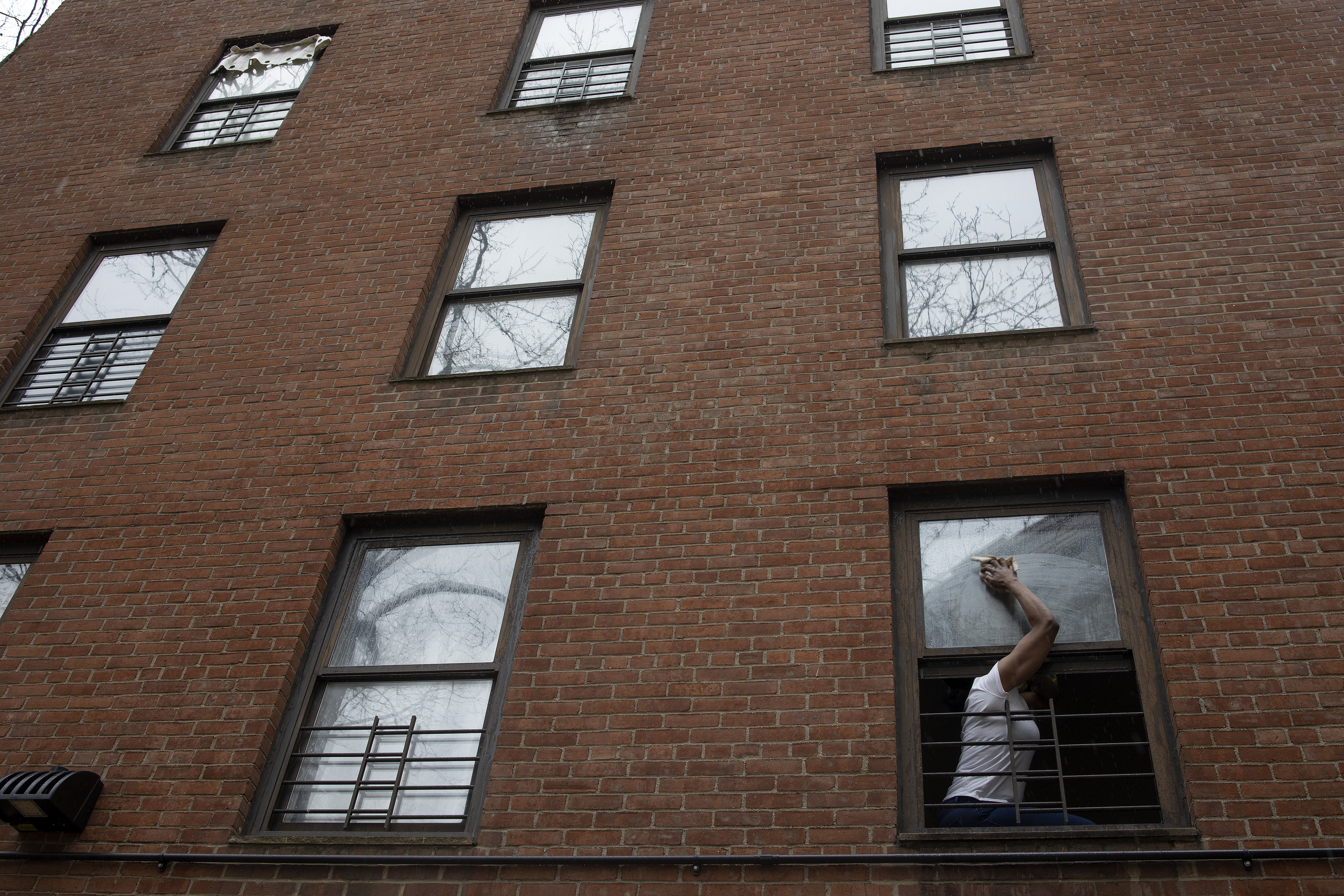 Photo of a woman in the window of a public housing complex in the Lower East Side