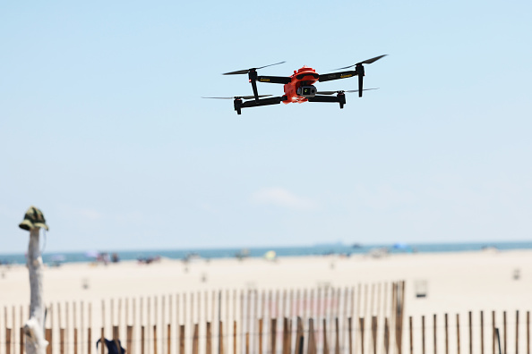 A drone hovers above a beach.