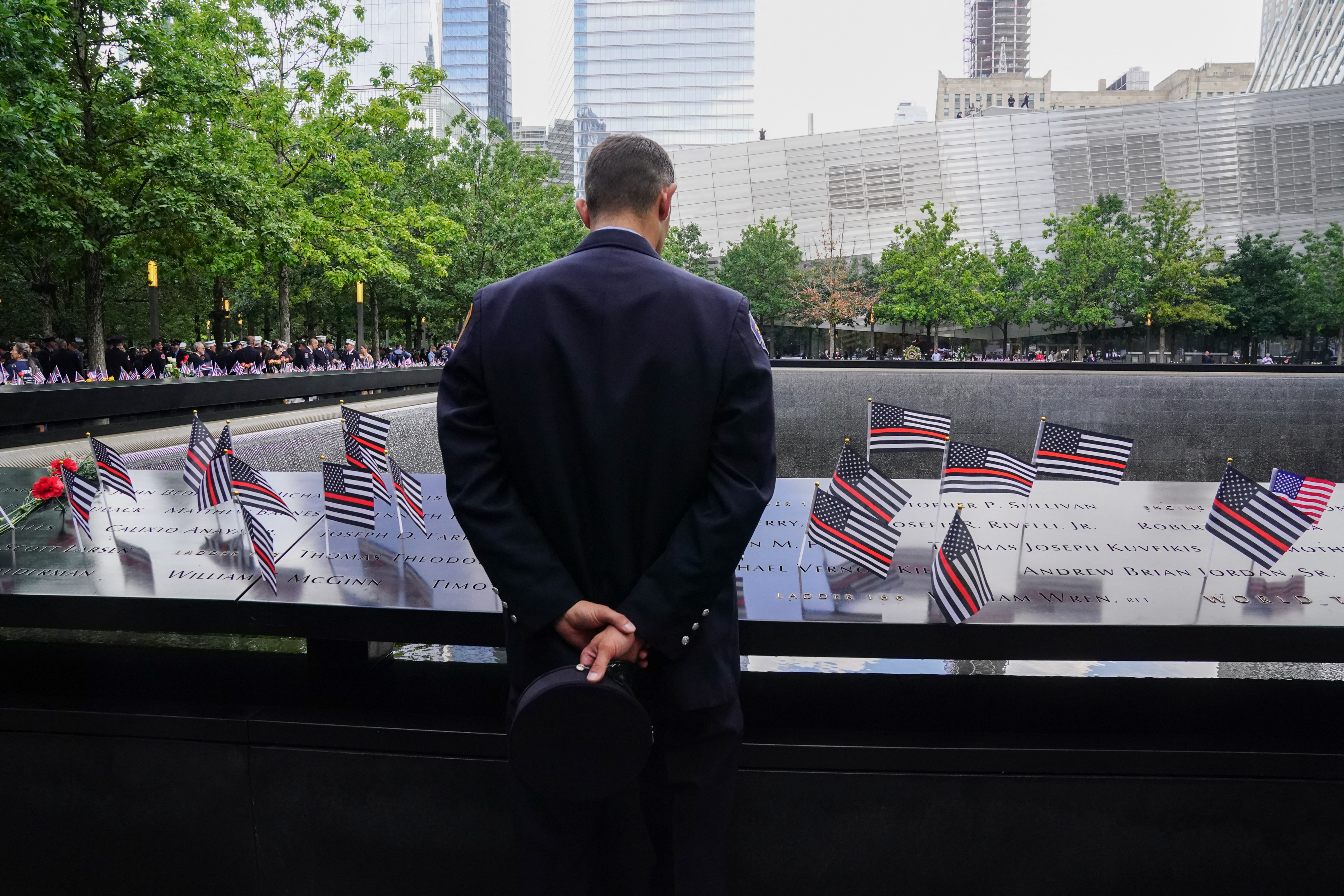 A New York firefighter stands before the 9/11 Memorial in the Financial District on Sept. 11, 2023.