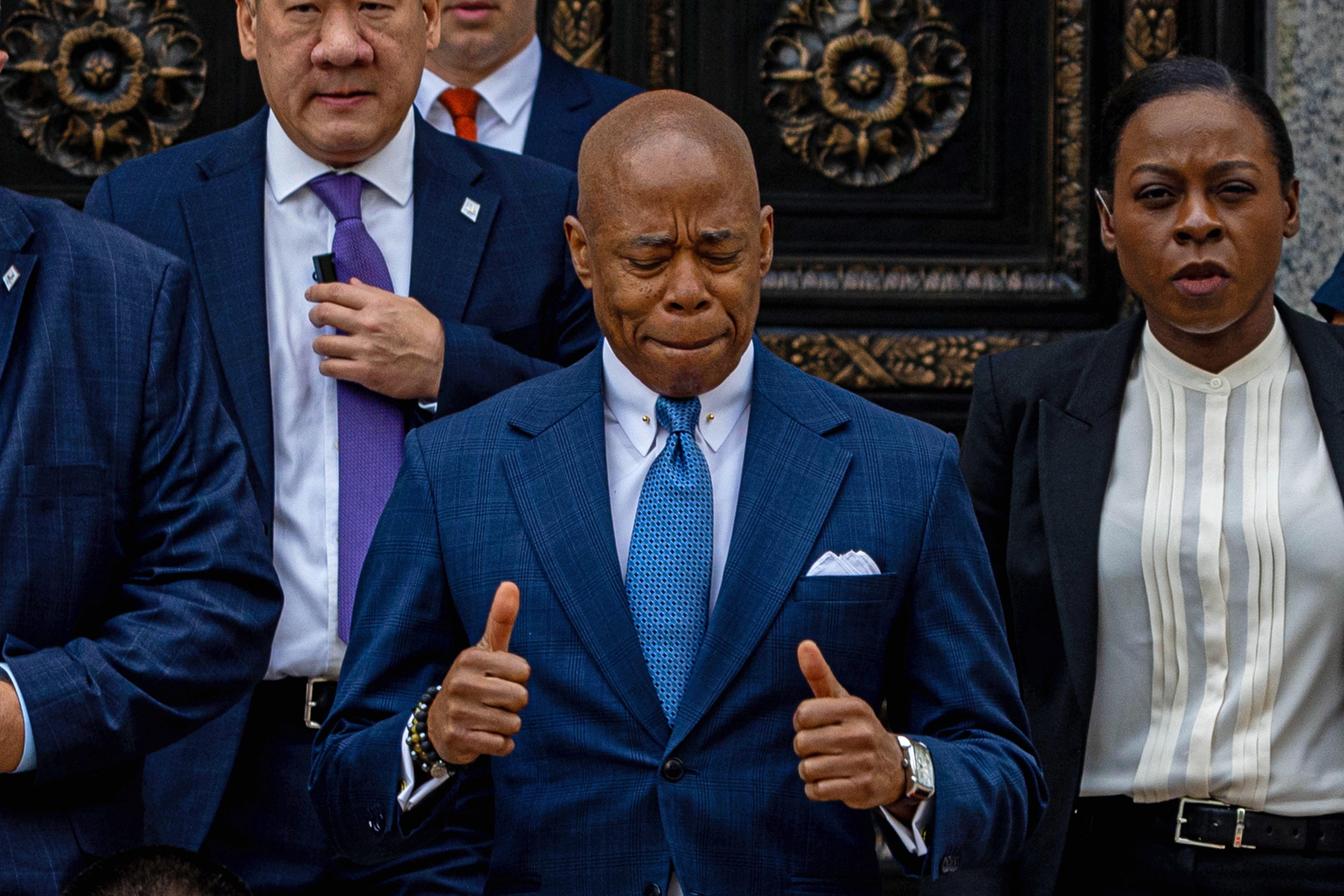 New York City Mayor Eric Adams smiles with his eyes and mouth closed and his thumbs up