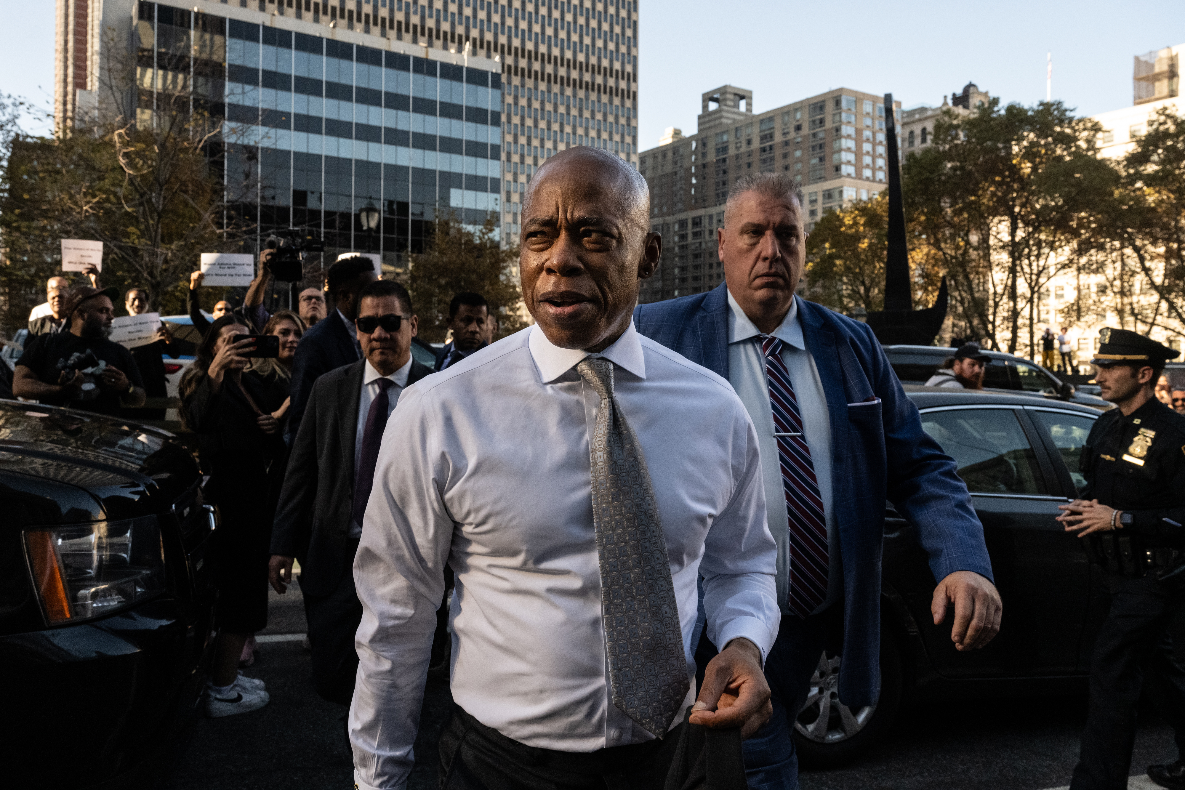 New York City mayor Eric Adams walks with security and staff behind him.