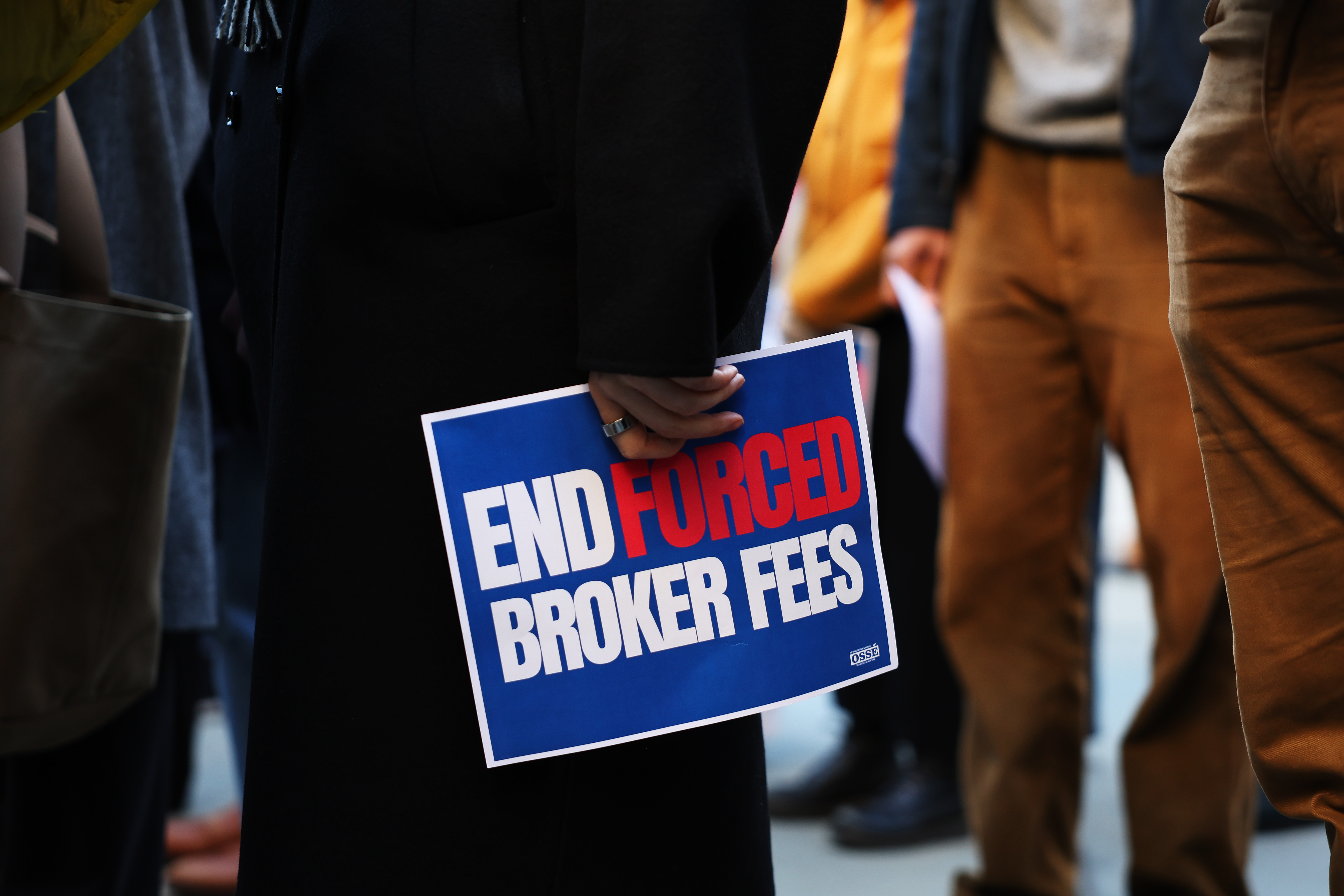 Photo of person holding broker fee sign