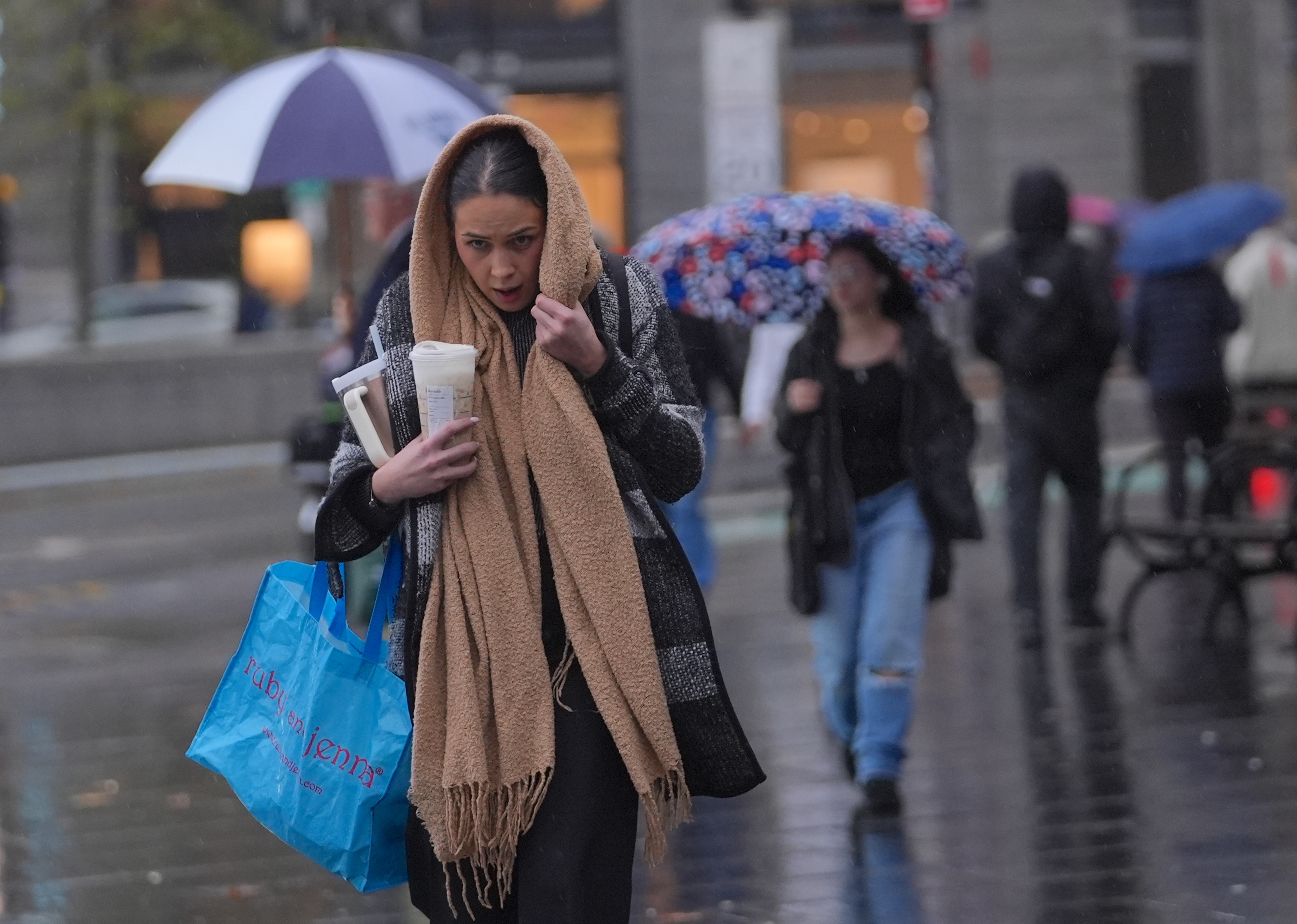 A woman walks through New York City in the rain.